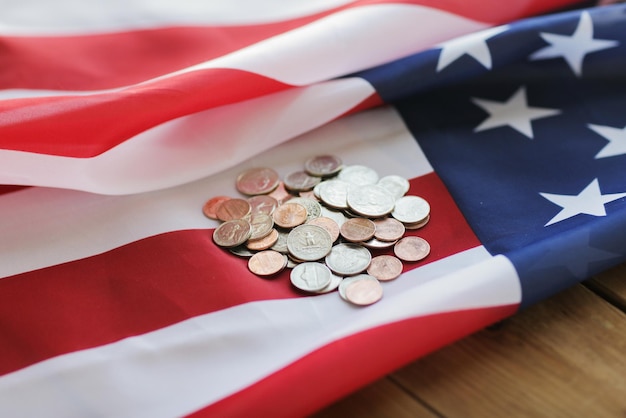 budget, finance, money, crisis and nationalism concept - close up of american flag and cent coins