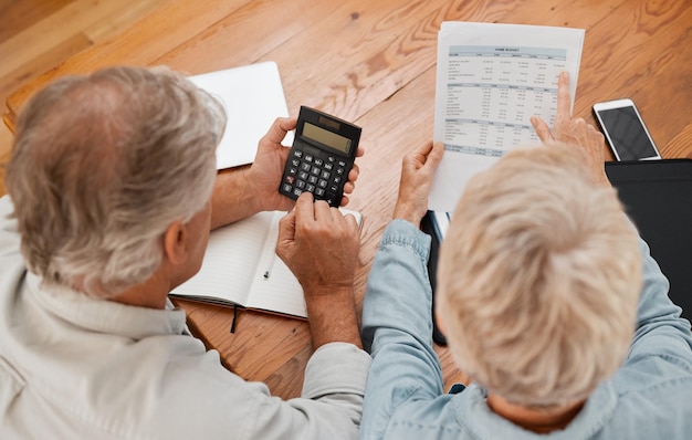 Budget finance and senior couple with calculator planning financial investments mortgage and tax papers Elderly woman counting bills debt and pension fund on bank statement with partner at home