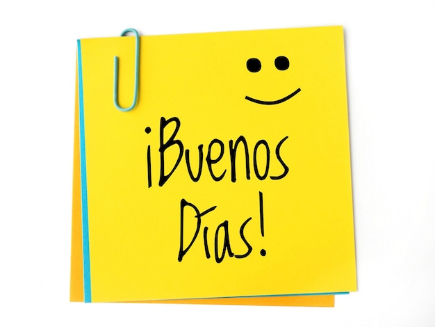 Buenos dias handwritten on a yellow sticky note and a happy face Good morning in spanish