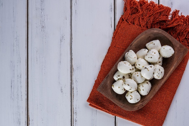 buffalo mozzarella balls sprinkled with oregano on a wooden tray