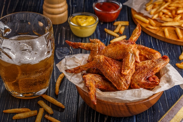 Buffalo wings with french fries and beer.