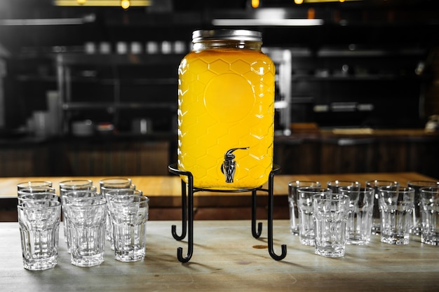 Фото Фруктовый желтый лимонад для шведского стола со стаканами на столе