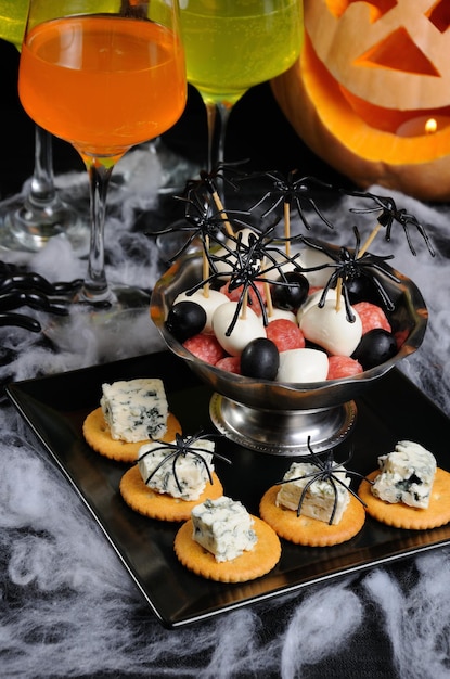 Buffet snack van cracker met blauwe kaas en baby salami mozzarella olijven op tafel halloween