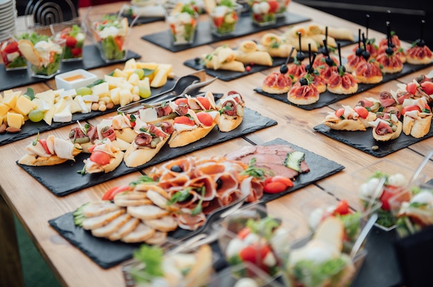 Buffet table of reception with cold snacks, meat and salads