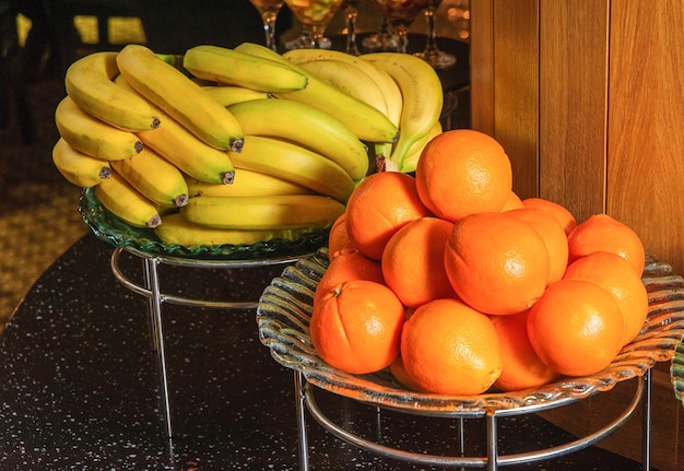 Un tavolo da buffet con cestini di frutta pieni di banane e arance