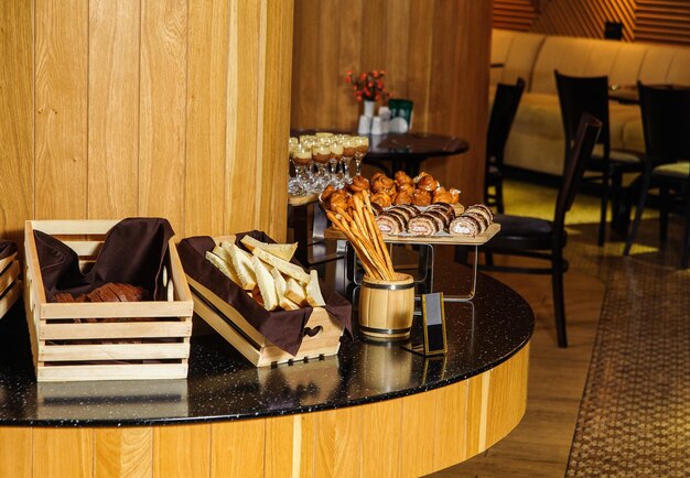 A buffet table with variety of bread in the wooden baskets