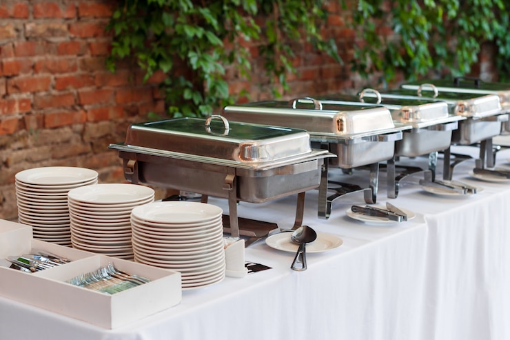 Foto buffet verwarmde trays staan in de rij klaar voor service. buiten buffetrestaurant, het hotelrestaurant.