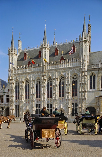 Foto buggy en paarden voor het stadhuis van brugge belgië
