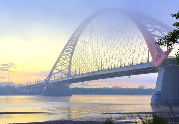 Foto bugrinskij-brug in de ochtendmist. nieuwe verkeersbrug aan de oevers van de grote siberische rivier ob