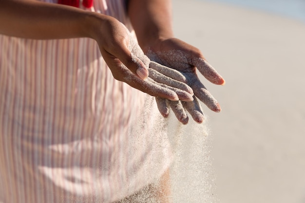 Buik van gemengd ras vrouw op strandvakantie zand morsen. vrije tijd in de buitenlucht vakantie aan zee.
