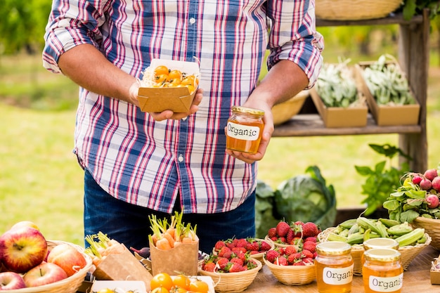 Buik van man die tomaten en domeinen verkoopt