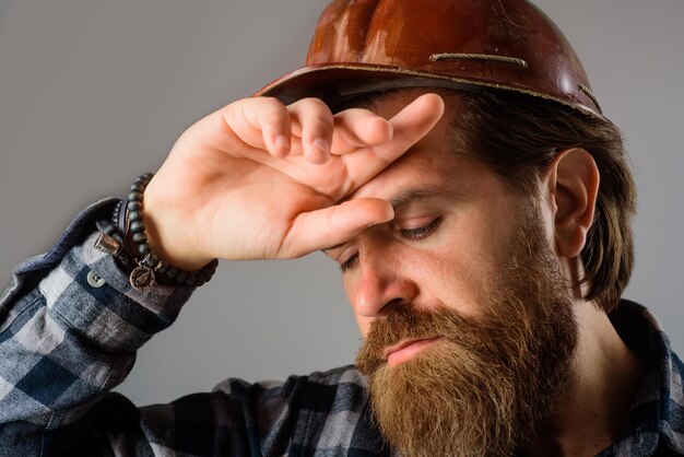 Builder concept building industry technology tired builder in hard hat close up of tired workman