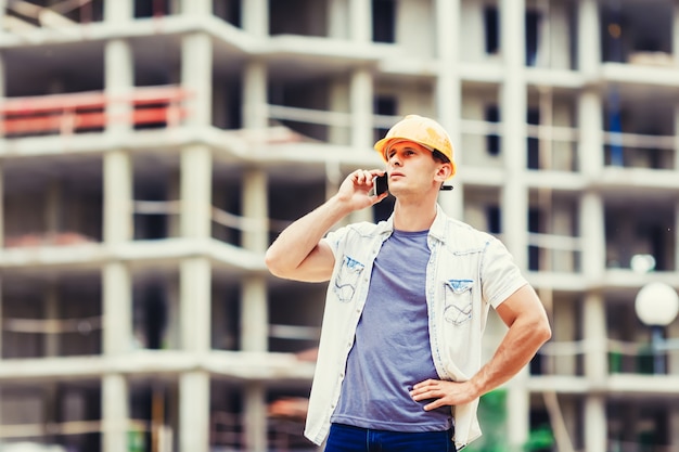 Builder at the construction site talking mobilephone