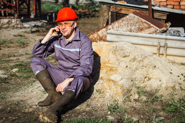 Ingegnere del costruttore con il casco che lavora al cantiere