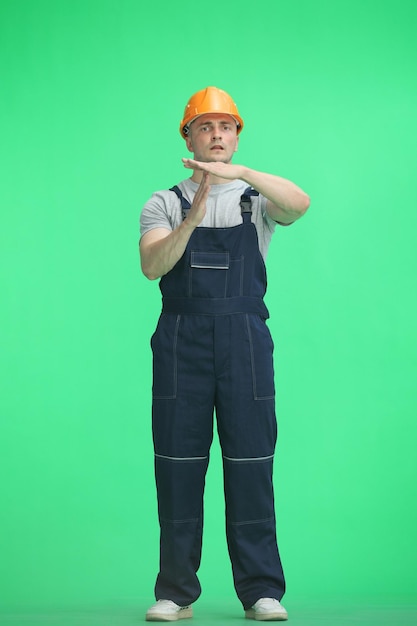 Photo the builder on a green background in full height shows a pause sign