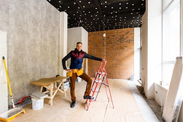 Builder handyman with construction tools. House renovation background.