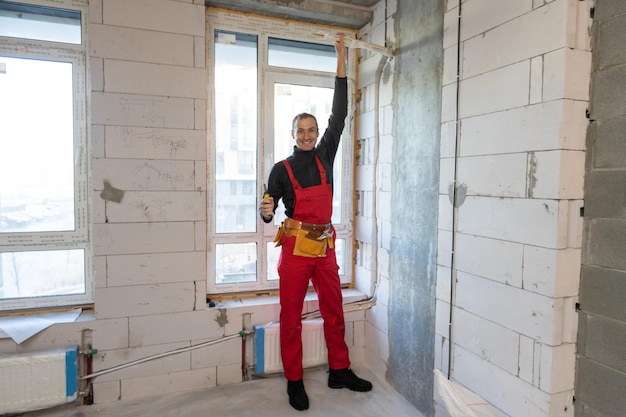 Builder handyman with construction tools. House renovation background.