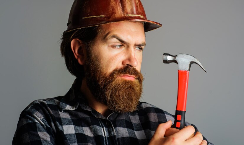  Builder in hard hat with hammer portrait of bearded workman in hardhat building repairment