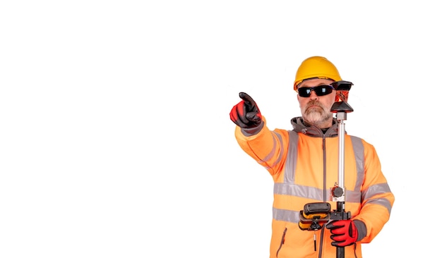 A builder in a hat and orange reflective fleece in safety glasses gives direction gesture