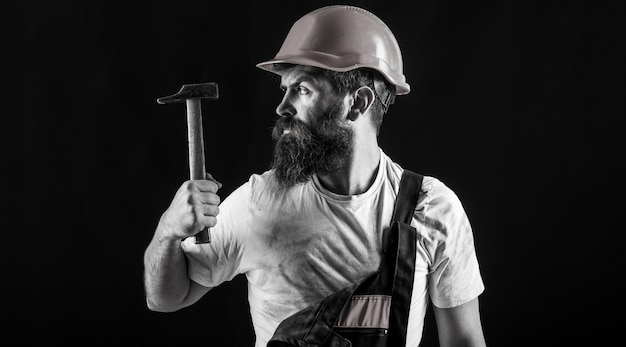 Builder in helmet hammer handyman builders in hardhat Handyman services Hammer hammering industry technology builder man concept Bearded man worker with beard building helmet hard hat