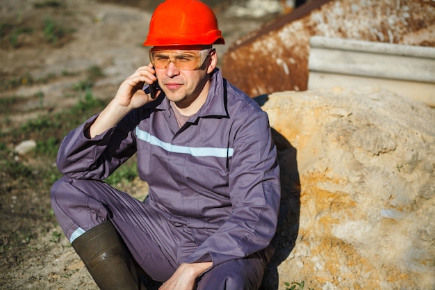 The builder is talking on the phone