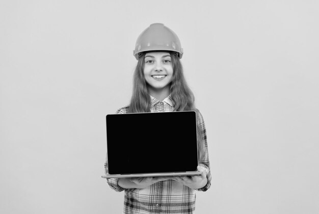 ビルダーの子供は、コンピューターの建物と建設のプレゼンテーション幸せな児童労働者を保持します。