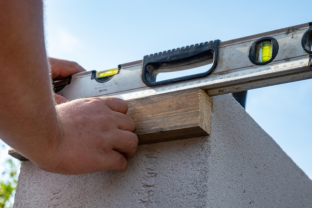 The builder measures the horizontal level of the brickwork Building level Building level in the ha