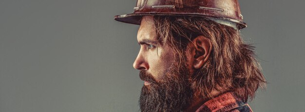 Builder in protective clothing and helmet Male builder Portrait bearded man with protec