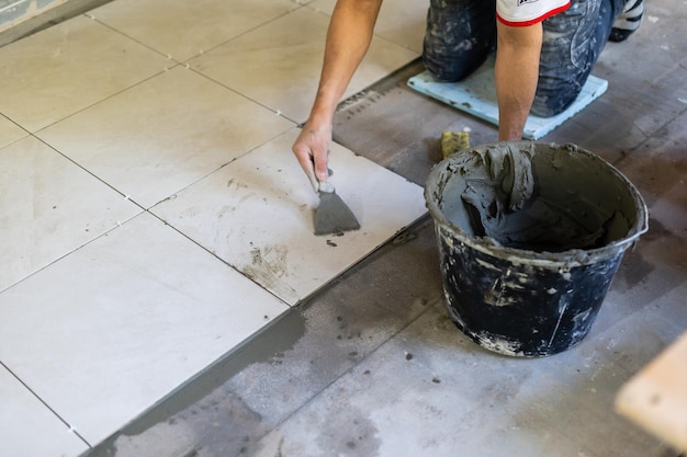 Builder puts the tiles on the floor, the repair