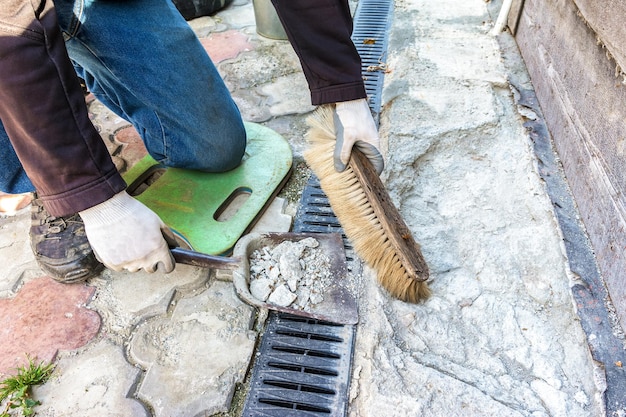 Foto il costruttore rimuove la spazzatura e prepara un luogo per la riparazione delle fondamenta