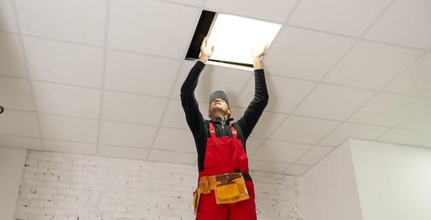 A builder replacing ceiling panel, working, armstrong.