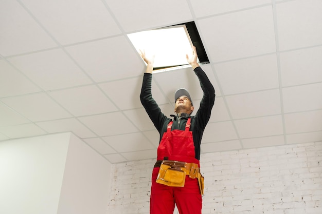 Builder replacing ceiling panel, working, ceiling\
armstrong.