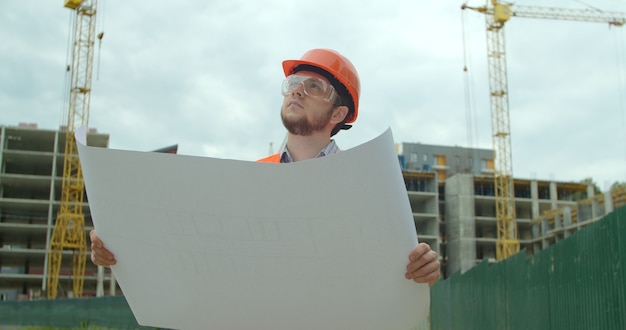 Builder standing in front of building under construction