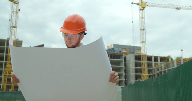 建設中の建物の前に立っているビルダー