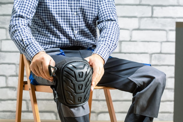 Builder wearing knee protection pads Concept of safety protective equipment at construction site Safety at work