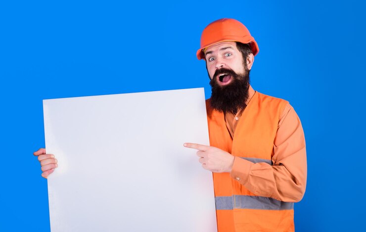  Builder with blank board repairman in protective helmet holds empty board with space for text man