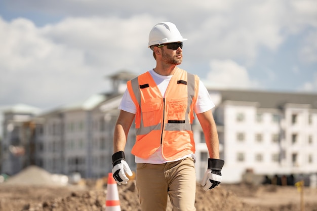 Builder with hardhat helmet on construction site construction builder worker in builders uniform nea