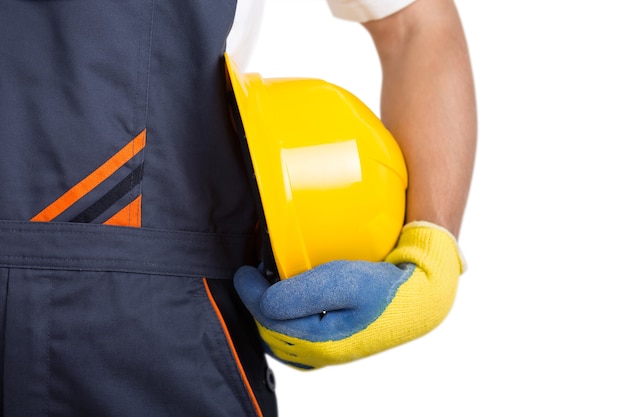 Builder with yellow hardhat and gloves isolated