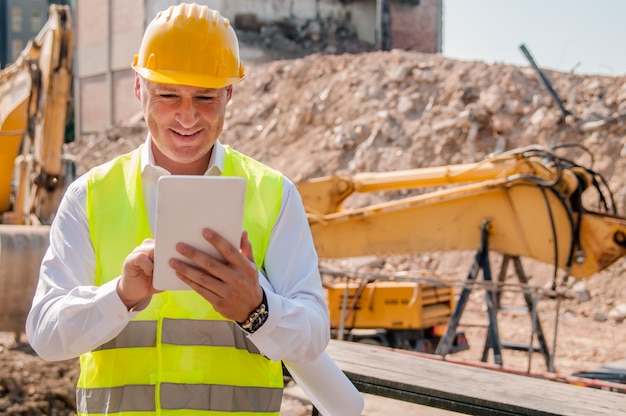 Attività lavoratore del generatore con compressa digitale sul cantiere