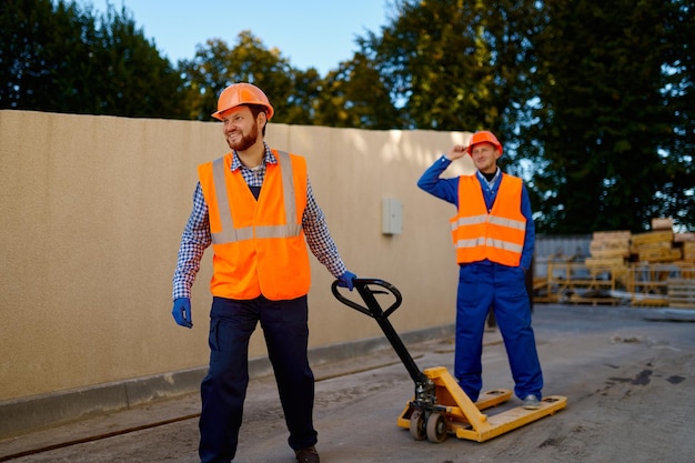 Builder worker using hand loader pallet truck