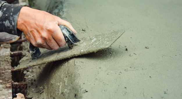 Foto i costruttori stanno intonacando le pareti del pavimento con cura.