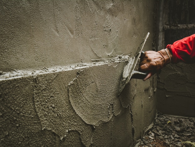 I costruttori stanno intonacando le pareti della casa con cura.