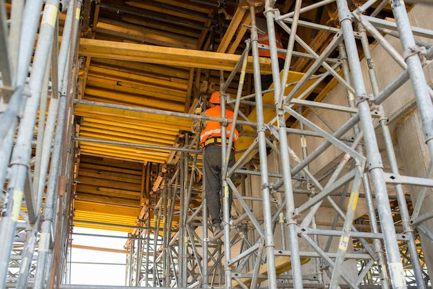 Builders in helmets assemble formwork during the construction of a transport bridge