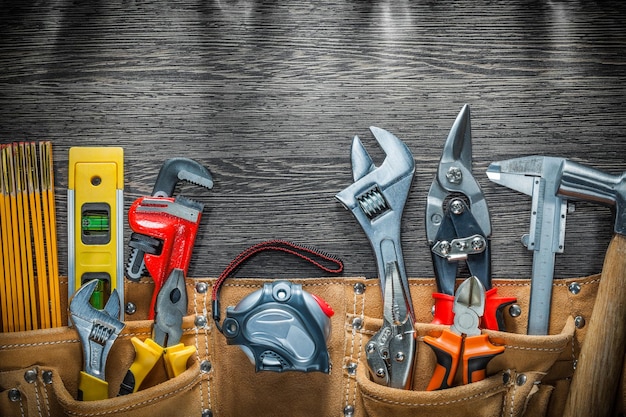 Building belt with construction tools on wooden board