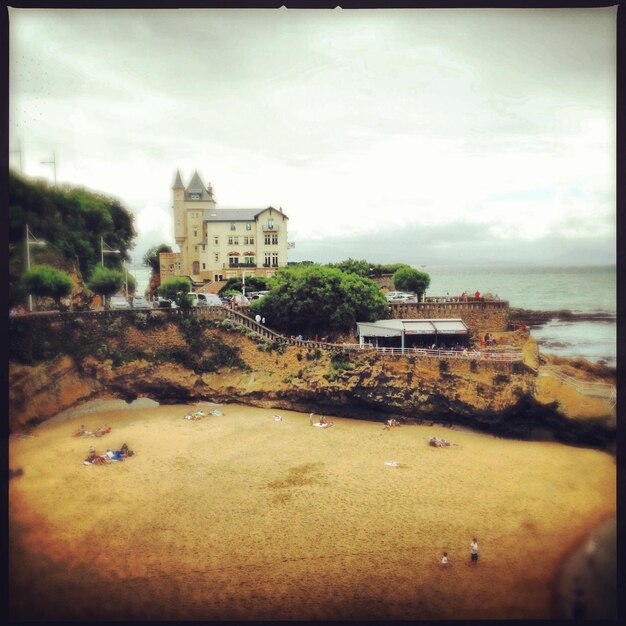 Photo building by beach against sky