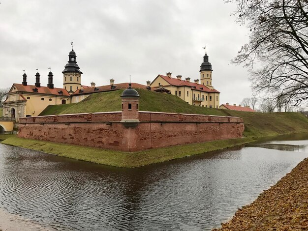 Building by river against cloudy sky