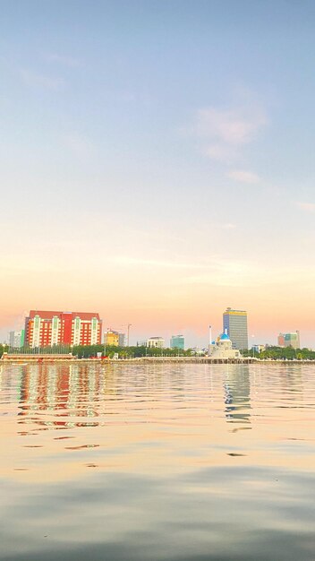 Building by sea against sky during sunset