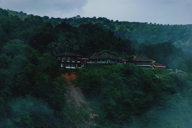 写真 空の向こうの森の木のそばで建物を建てる