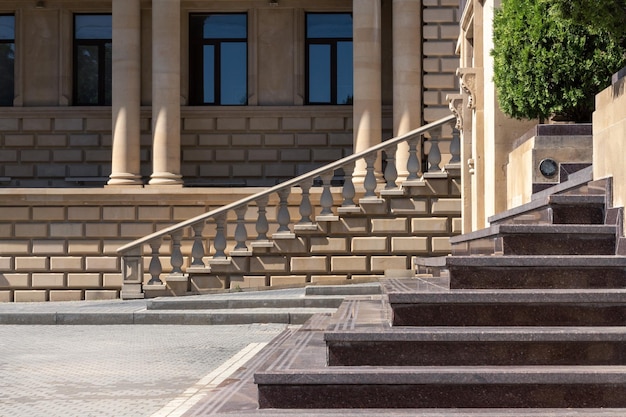 Building of classicism style with relief blocks colonnade and stone staircase with balustrade