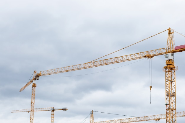 Building construction cranes against sky